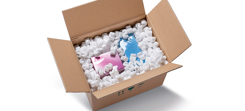 
		  A cardboard box containing a children’s toy and S-shaped white packaging chips